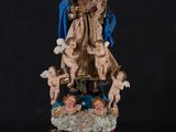 a statue of the virgin with angels and chers on a black background