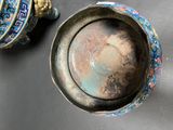 a silver bowl and a blue and white vase on a table