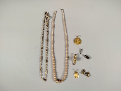 Deux colliers, un bracelet et une bague sont posés sur une table.