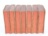 several old books stacked on top of each other on a white surface