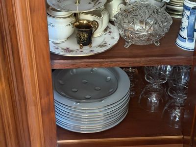 de nombreuses assiettes et tasses posées sur une étagère dans un placard