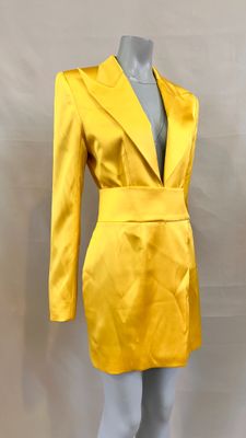 un gros plan d'un mannequin vêtu d'un costume jaune, sur un autre mannequin