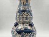 a blue and white vase sitting on a white surface
