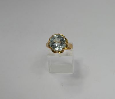 a gold ring with a blue topaz stone in the center