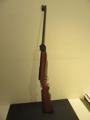 un pistolet posé sur une table, à côté d'un livre et d'une lampe