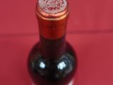 a bottle of wine that is sitting on a red surface