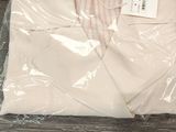 une chemise blanche emballée dans du plastique, posée sur une table