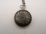 a silver pocket watch on a chain on a white surface