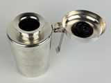 an image of a silver coffee pot and a cup on a white surface