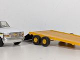 a toy truck with a flatbed trailer attached to it