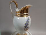 a white and gold vase with blue flowers on it