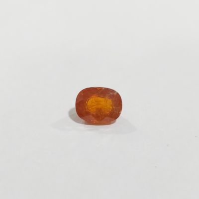 un gros plan d'une pierre précieuse orange sur une surface blanche