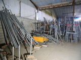 a room with a lot of metal pipes and a yellow cart