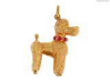 une image représentant un pendentif en forme de caniche en or orné d'une pierre rouge