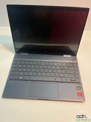 un ordinateur portable ouvert posé sur une table blanche