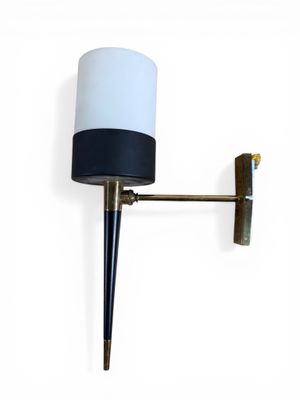 the wall lamp is mounted on the wall with a black and white shade