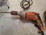 a drill that is sitting on the floor next to other tools