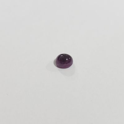 gros plan d'une pierre précieuse violette sur une surface blanche