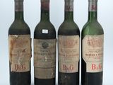 four bottles of wine are lined up in a row on a table
