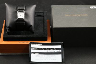a box with a watch in it and a card attached to it