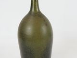 a green vase that is sitting on a white surface