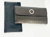 un portefeuille en cuir muni d'un anneau métallique sur le devant et un portefeuille en cuir noir muni d'un anneau métallique au dos