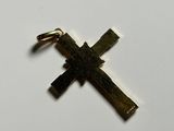a close up of a gold cross on a white surface