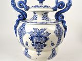 un vase bleu et blanc posé sur une surface blanche