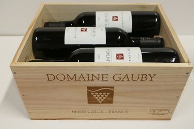 trois bouteilles de vin dans un coffret en bois sur une table