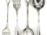 four spoons and a fork on a white surface