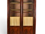 an antique mahogany bookcase with glass doors and shelves