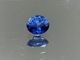 un gros plan d'un saphir bleu posé sur une surface réfléchissante