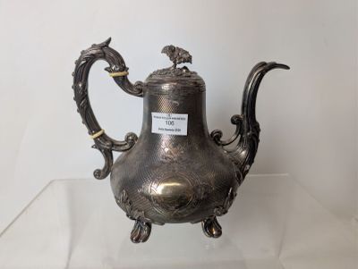 a silver tea pot on display on a glass table