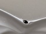 a close up of a metal surface with a hole in it