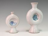 two small vases sitting next to each other on a table