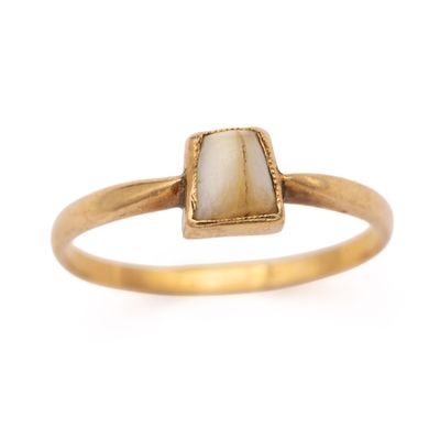 un gros plan d'une bague en or sertie d'une pierre blanche
