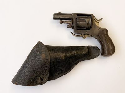un petit revolver posé sur une surface blanche