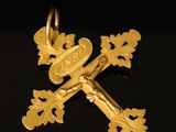 gros plan d'une croix en or sur une surface noire