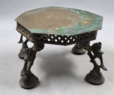 une petite table en bronze sur laquelle est posé un oiseau