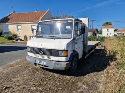 un camion blanc garé sur le bord de la route