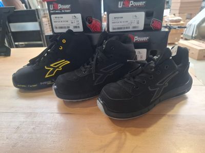 two pairs of shoes are on a table with boxes of power shoes