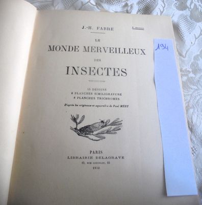 un livre ouvert posé sur un lit, avec une feuille de papier dessus