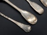 three silver spoons and two silver spoons on a black surface
