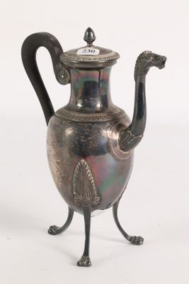 a silver tea pot with a black handle on a stand