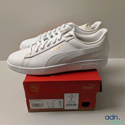 baskets Puma en cuir blanc avec un logo doré sur la semelle