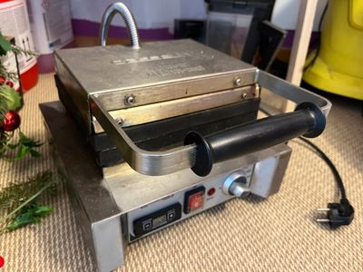 an image of a commercial pizza maker on the floor