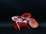 a close up of a red fish figurine on a black background