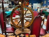 un rouet posé sur une table en bois dans une pièce