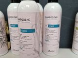 several bottles of shampooing are lined up on a shelf