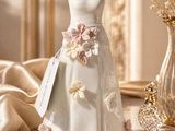 a vase with flowers and a dress on it on a table